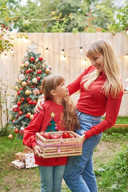 Familie Kerstmis in juli Portret van meisje in de buurt van kerstboom met cadeaus Pine versieren Winter