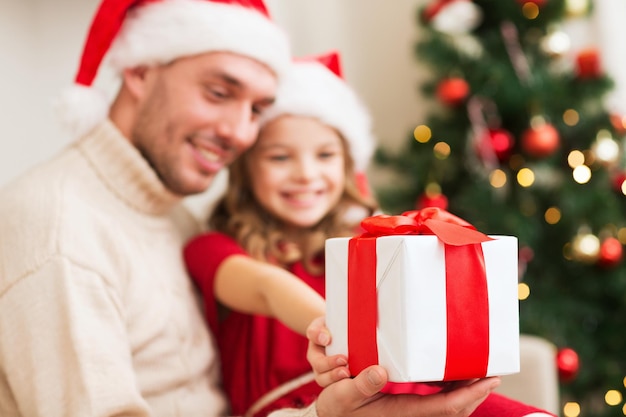 familie, Kerstmis, vakantie, geluk en mensen concept - close-up van lachende dochter die vader geschenkdoos geeft