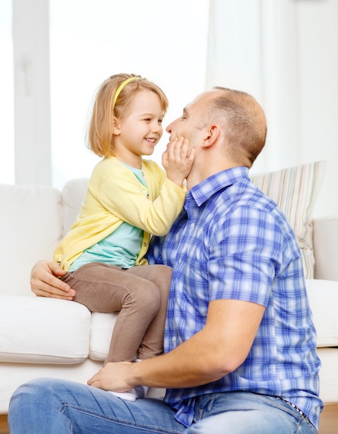 familie, kind en geluk concept - glimlachende vader en dochter die thuis spelen