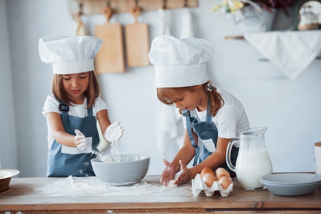 Familie kinderen in witte chef-kok uniform bereiden van voedsel in de keuken.