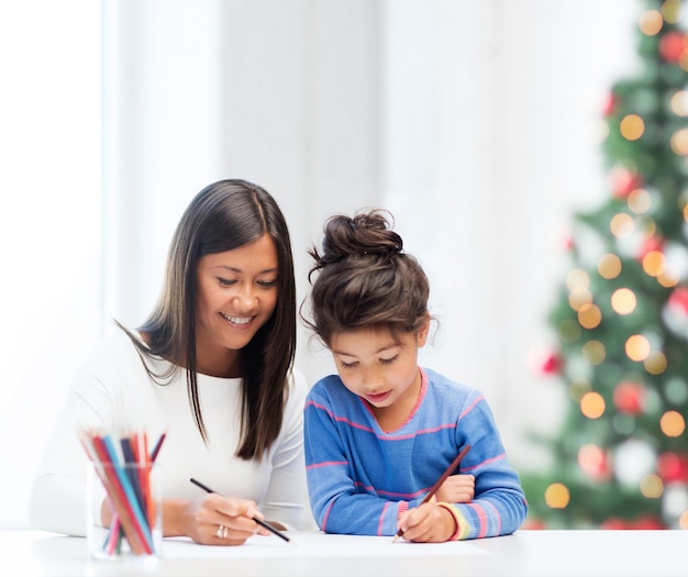 familie, kinderen, Kerstmis, Kerstmis en gelukkige mensen concept - moeder en dochter tekenen