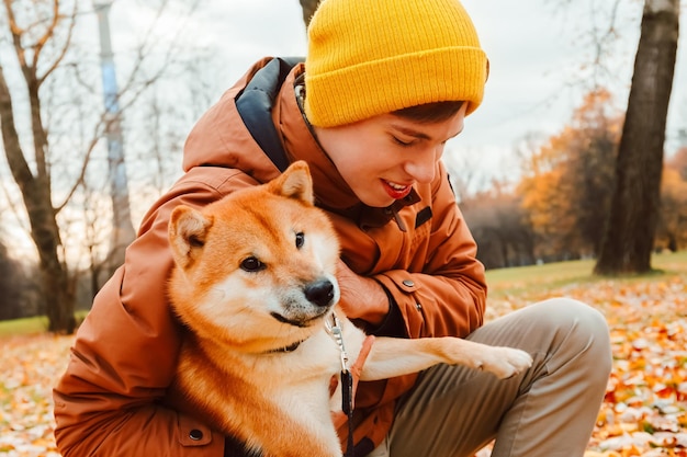 Familie knuffelt hond liefdevol Oprechte vriendschap met huisdier Eigenaren wandelen met de hond in het park en aaien het Akita Inu-ras Geestelijke gezondheid en stress verlichten door huisdier Mensen knuffelen hond