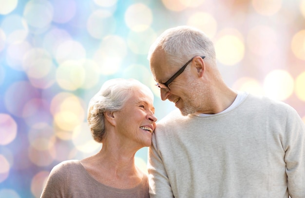 familie, leeftijd, liefde, relaties en mensen concept - gelukkig senior paar over vakantie lichten achtergrond