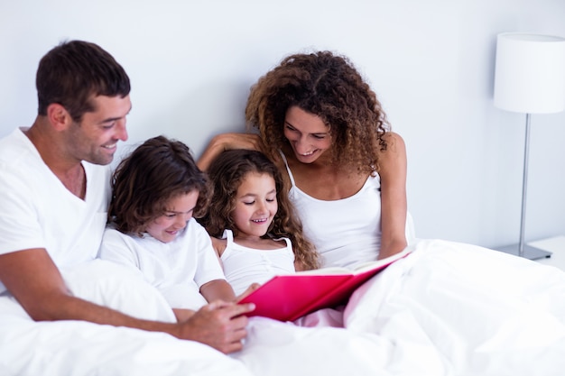 Familie leesboek samen op bed