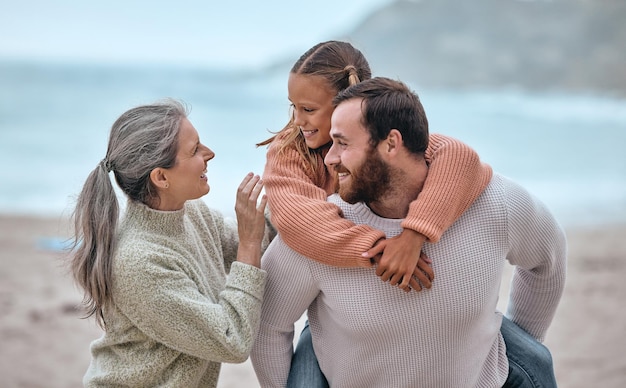 Familie liefde en meeliften op het strand op vakantie vakantie of reis Ondersteunende zorg en oma met vader dragen meisje buiten genieten van quality time samen plezier maken of hechten aan zandige kust