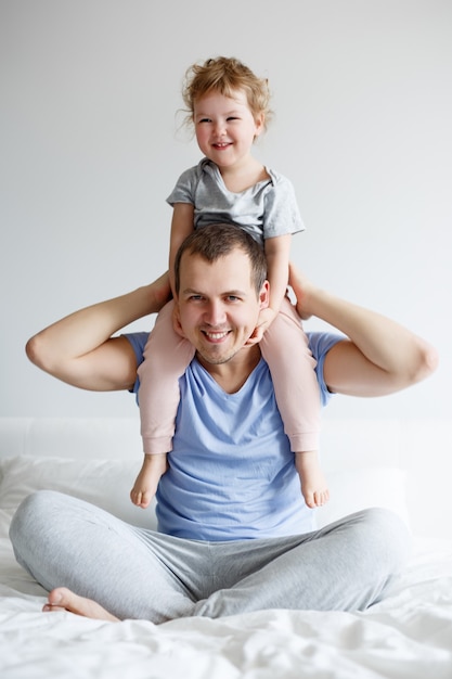 Familie, liefde en vaderschap concept - gelukkige vader die plezier heeft met zijn schattige kleine meisjesdochter thuis