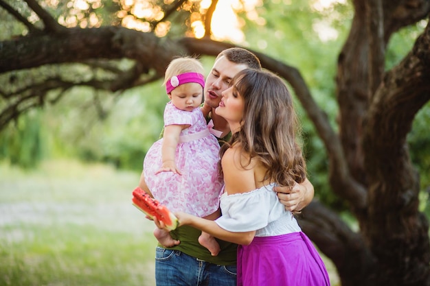 Familie met babymeisje op picknick bij de oude boom