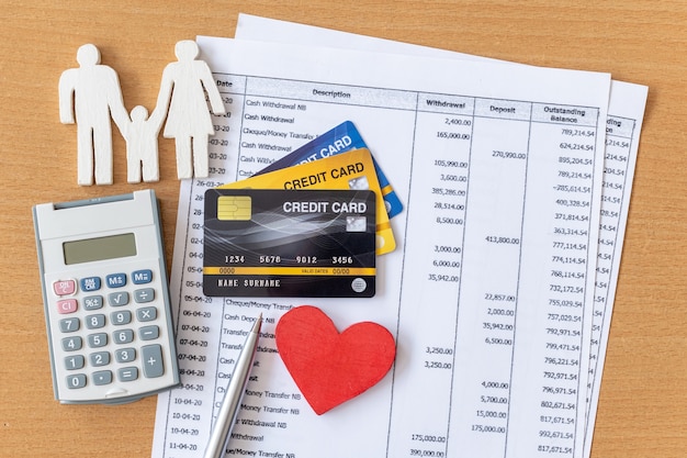 Familie model en rekenmachine op bankafschrift en creditcard op een houten tafel.