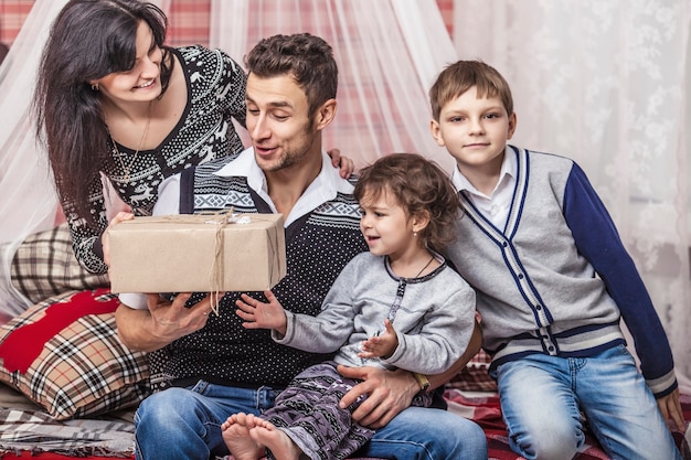 Familie moeder vader en kinderen geven elkaar cadeaus in je huis winter decor