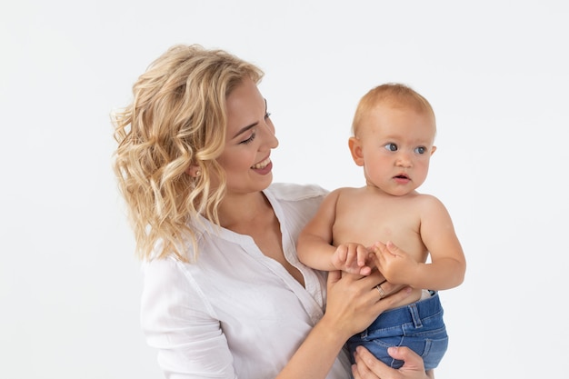 Familie, moederschap en familieconcept - Jonge moeder die haar baby op witte achtergrond houdt.