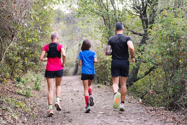 Familie oefent trailrunning in het bos