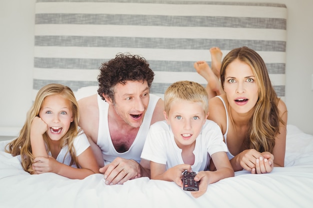 Familie ontspannen op bed thuis