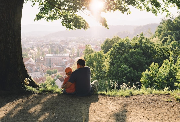 Familie op de achtergrond van ljubljana slovenië europa man met zijn kind jongen kijken naar panorama van europese stad vanaf de heuvel vader en kind buiten in de lente of zomer