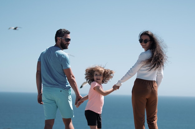 Familie op het strand mensen plezier op zomervakantie vader moeder en kind hand in hand weer