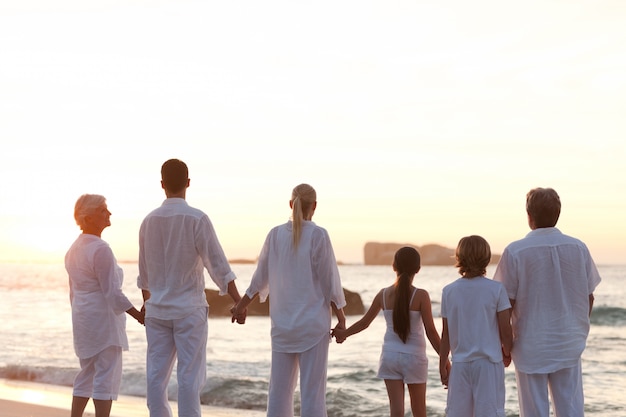 Familie op het strand tijdens de zonsondergang