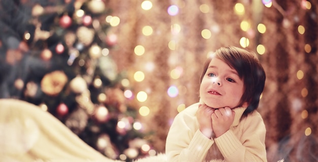 Familie op kerstavond bij open haard. kinderen openen kerstcadeautjes. kinderen onder de kerstboom met geschenkdozen. ingerichte woonkamer met traditionele open haard. gezellige warme winteravond in huis.