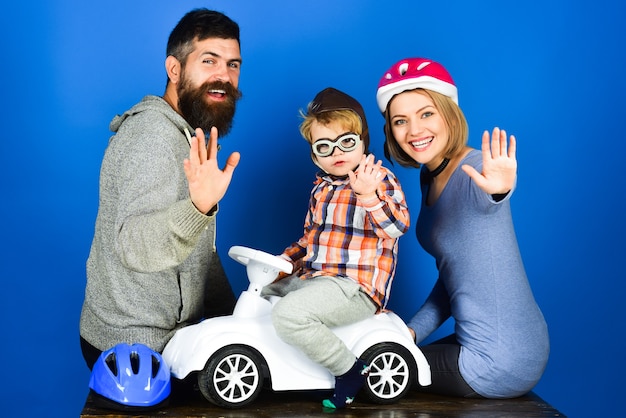 Familie ouderschap adoptie en mensen concept gelukkige moeder vader met beschermende helm zoon rijden op