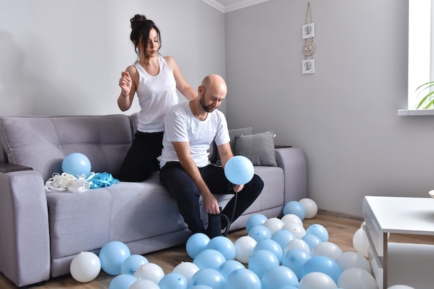 Familie paar blauwe en witte ballonnen blazen