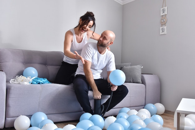 Familie paar blauwe en witte ballonnen blazen