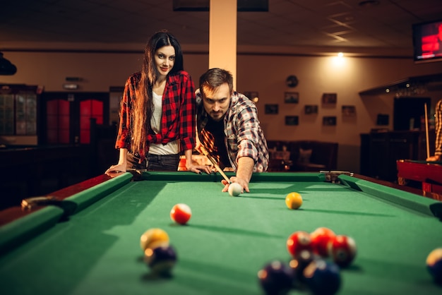 Familie paar speelt in biljartkamer