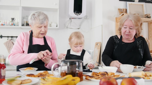 Familie pannenkoeken eten en thee drinken aan tafel