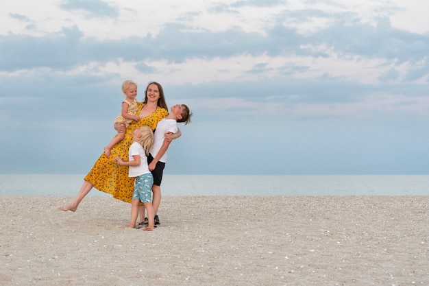 Familie plezier op zomervakantie. Moeder en drie kinderen aan zee.