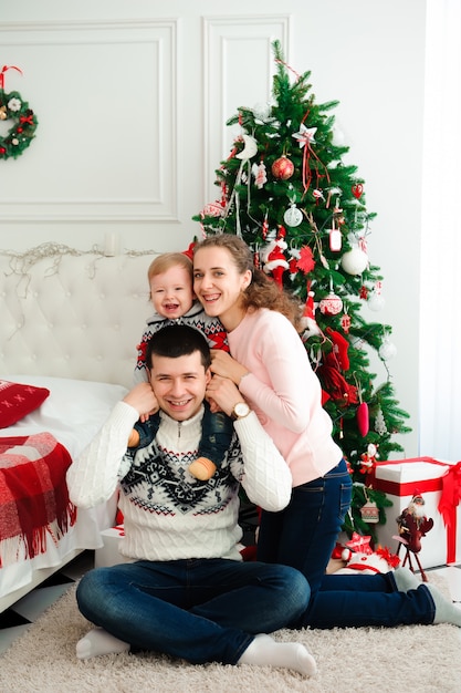 Familie poseren door de kerstboom