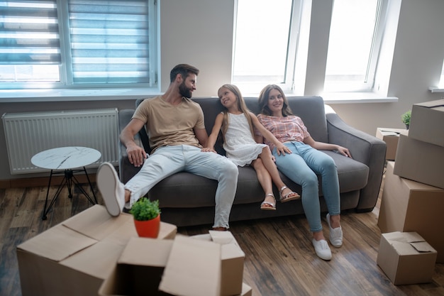 Familie rusten op de bank na verhuizing naar een nieuw huis