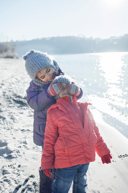 Familie samen genieten van de winter, kinderen wandelen op het strand in de winter