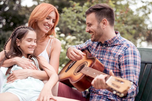 Familie samen gitaar spelen in het park