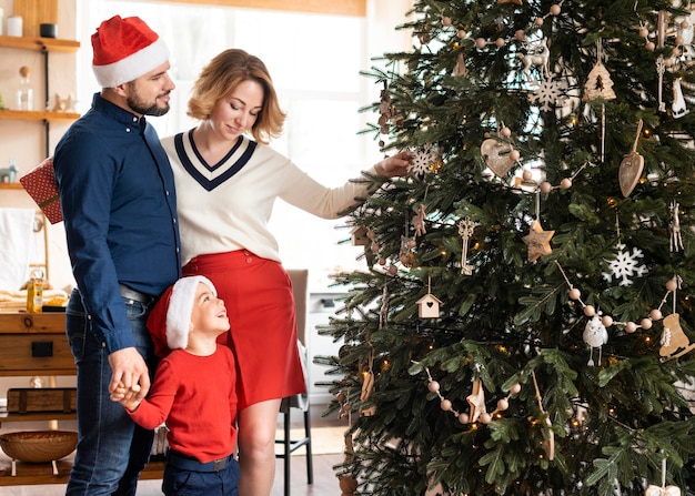 Familie samen kerst vieren naast boom