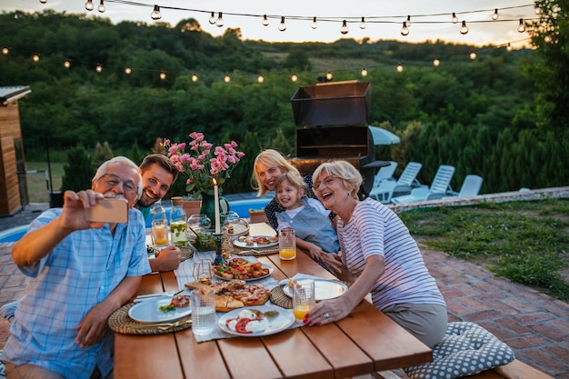 Foto familie selfie aan de eettafel in de achtertuin