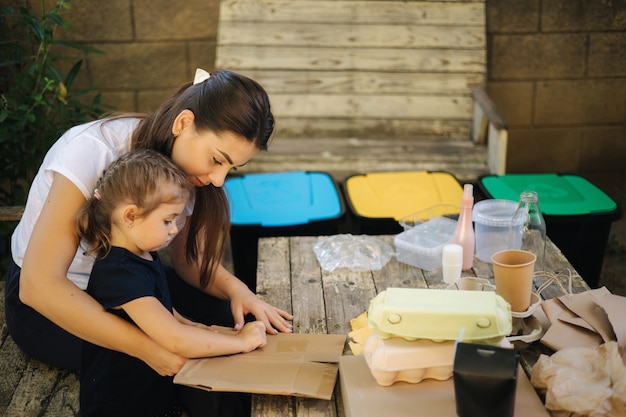 Familie sorteren afval thuis op achtertuin concept van recycling buitenshuis moeder en dochter zorgzaam