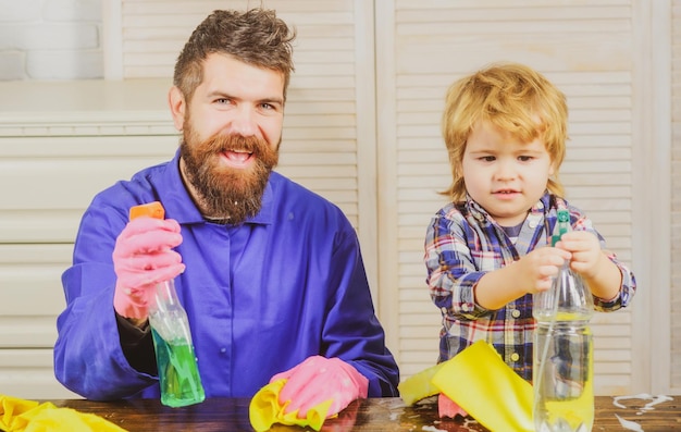 Familie tijd concept vader met zoon en schoonmaakspullen vader en kind hebben plezier tijdens het schoonmaken man