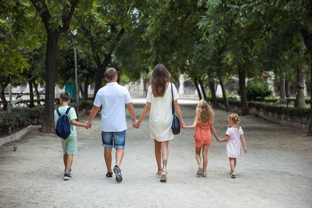 Familie tijd doorbrengen samen vrolijke ouder met kinderen wandelen in het park bij mooi weer