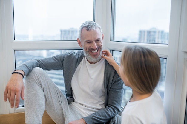 Familie tijd. Een vader die met zijn dochter voor het raam zit