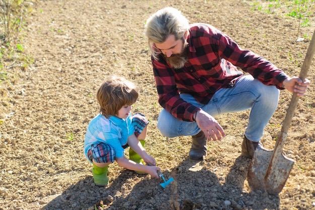 Familie tuinieren vader en kind planten in de tuin lenteplanten