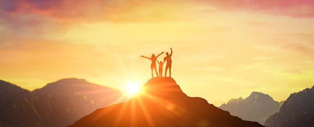 Familie Vader Moeder en dochter ontmoeten dageraad op piek in bergen Familie op bergtop met open armen verwelkomen nieuwe dag met zonsopgang Succes Leiderschap Winnaar bovenop