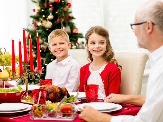 familie, vakantie, generatie, kerstmis en mensenconcept - glimlachende familie die thuis dineert