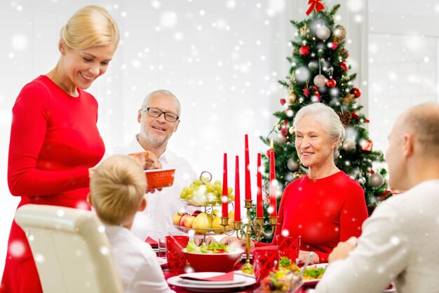 familie, vakantie, generatie, kerstmis en mensenconcept - glimlachende familie die thuis dineert