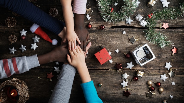 Familie van gemengde rassen die hun handen stapelen in Kerstmis het plaatsen