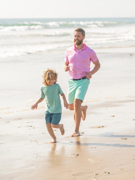 Familie van papa man en kindjongen die op zonnig strand samen reizen