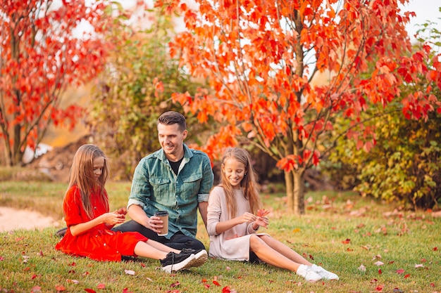 Familie van vader en kleine dochters op mooie herfstdag in het park