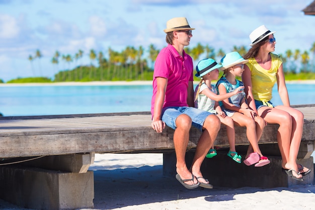 Familie van vier op houten steiger in de maldiven