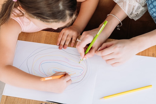 Familie vrijetijdsbesteding. creatieve en listige moeder en dochter die samen tekenen. liefdevolle relatie en verantwoordelijk ouderschap.