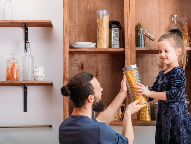 Familie vrijetijdsbesteding. Vader en zijn schattige dochtertje genieten van samen thuis koken.