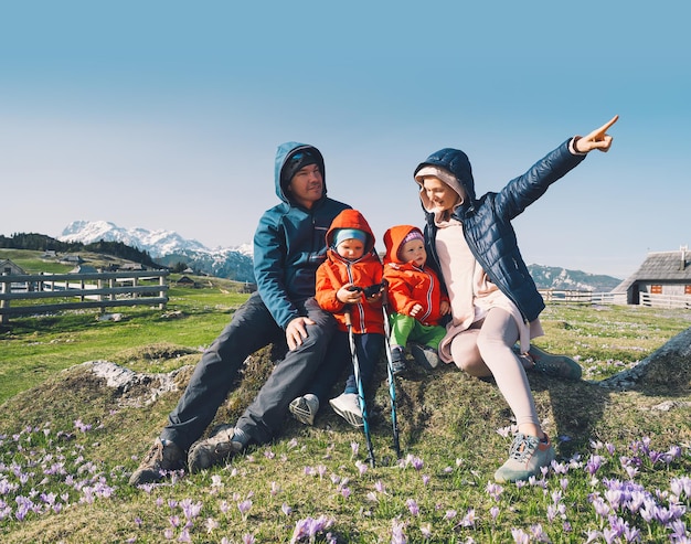 Familie wandelen buiten in de bergen Lente natuur in Slovenië Europa Velika Planina of Big Pasture Plateau in Kamnik Alpen Seizoen van bloeiende paarse saffraan of violet krokussen in de Alpen van de bergen