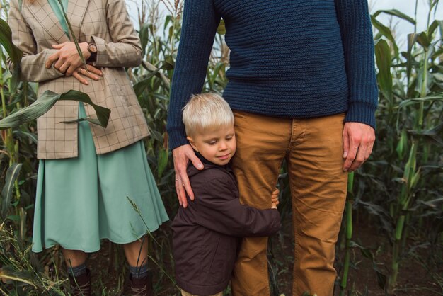 Familie wandelen in maïsveld bij herfst kind knuffel ouder