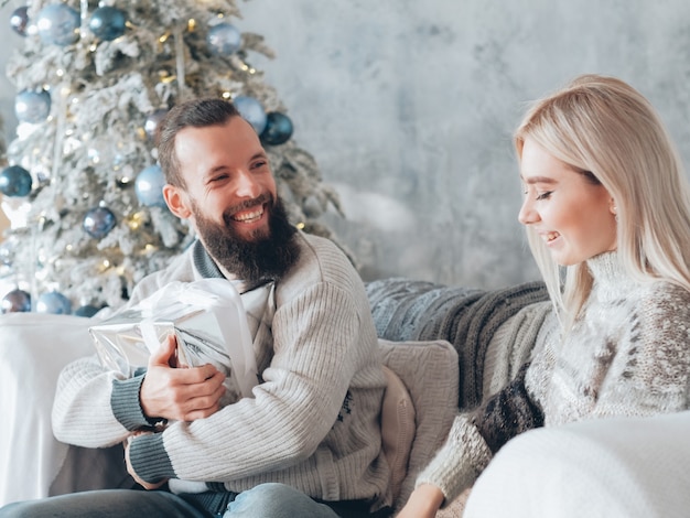 Familie wintervakantie. Kerel is blij om een geschenk van zijn vriendin te ontvangen