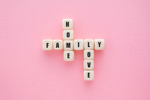 Foto familie woord op houten blokken roze achtergrond